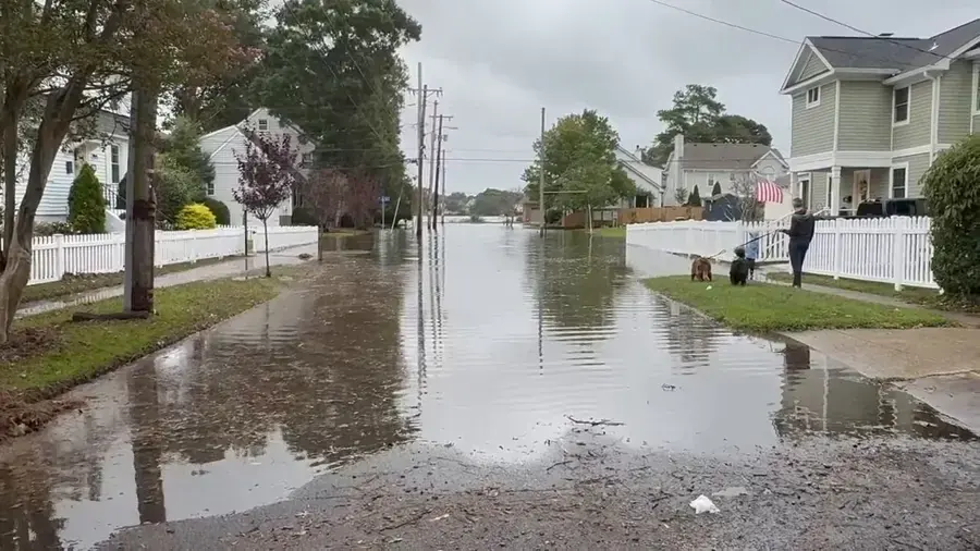 Storm water flooding a residential street lined with houses, storm and flash flood cleanup in Brookline, MA